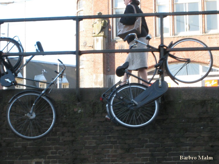 Cyklar vid kanal i Amsterdam